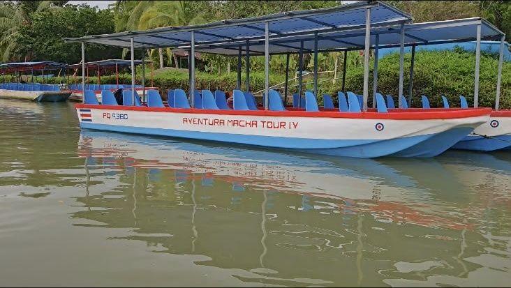 Bote de techo rojo y azul amarrado junto a un canal